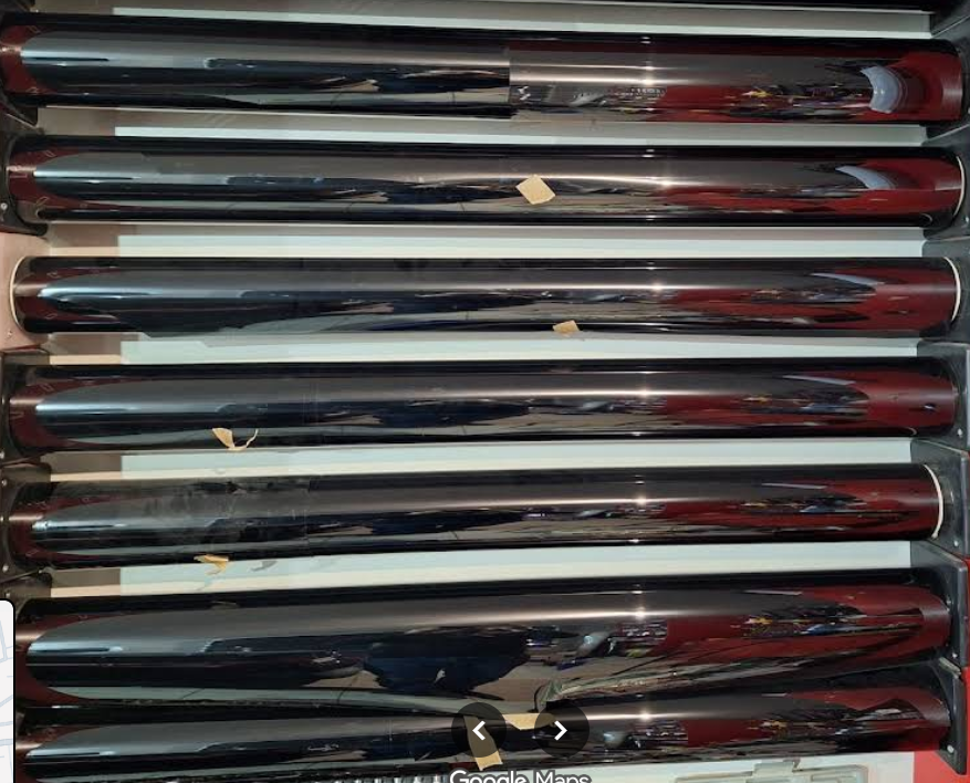 Rolls of dark tint film stored on the workshop shelf